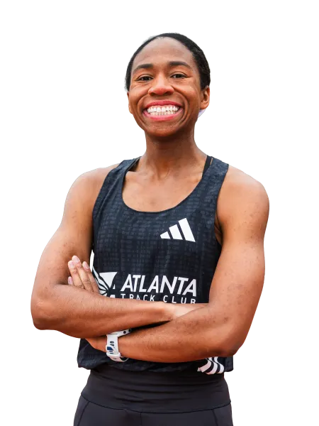 Smiling athlete in Atlanta Track Club uniform with arms crossed, showing confidence and fitness.
