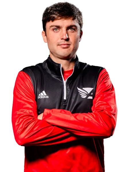 a man wearing a red and black jacket with his arms crossed