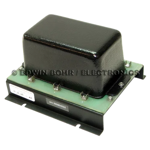Black rectangular electronic transformer mounted on a green circuit board with metal clips and screws.