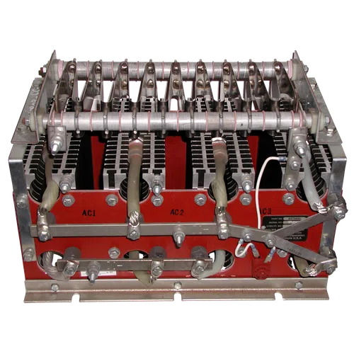 Industrial electrical transformer with metal coils, connectors, and wiring mounted on a red base.