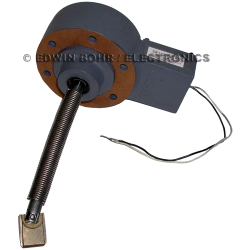 Gray rotary electric motor component with round mounting plate and attached spring-loaded shaft with wires.