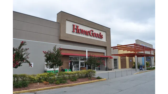 Exterior view of a HomeGoods store with clear signage and landscaped entrance under a cloudy sky.
