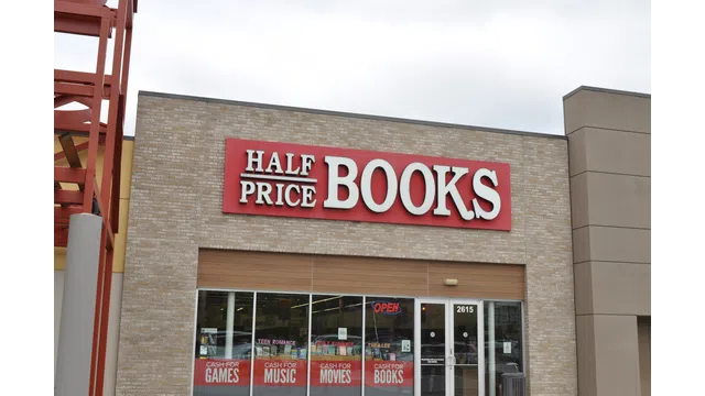 Exterior of Half Price Books store with signage advertising cash for games, music, movies, and books.