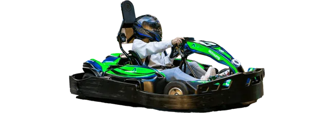 Person wearing helmet driving a green and blue go-kart on a black track isolated on white background.
