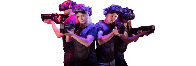 Four people wearing VR headsets and vests aiming laser tag guns with red and purple lighting