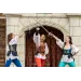 Three women in Renaissance costumes clash swords in f