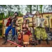 Three musicians perform with guitar, drums, and accor