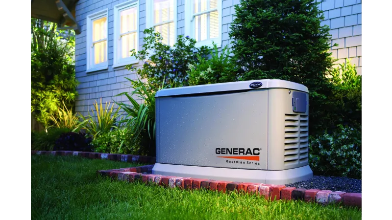 Generac standby generator installed outside a modern brick house with wooden fence and green lawn.