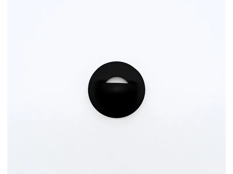 Black circular wall-mounted light fixture with a semi-hidden white bulb against a white background