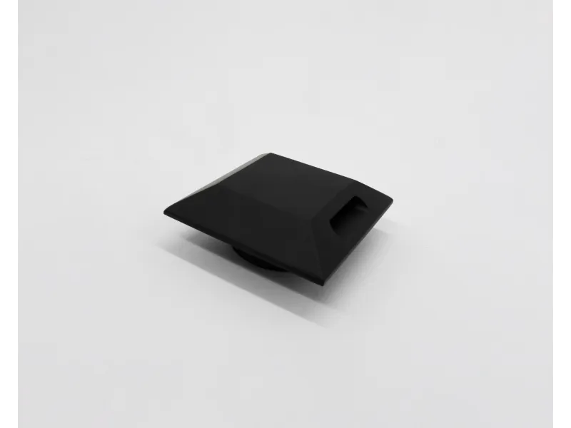 Black geometric-shaped object with angular facets on a plain white background.