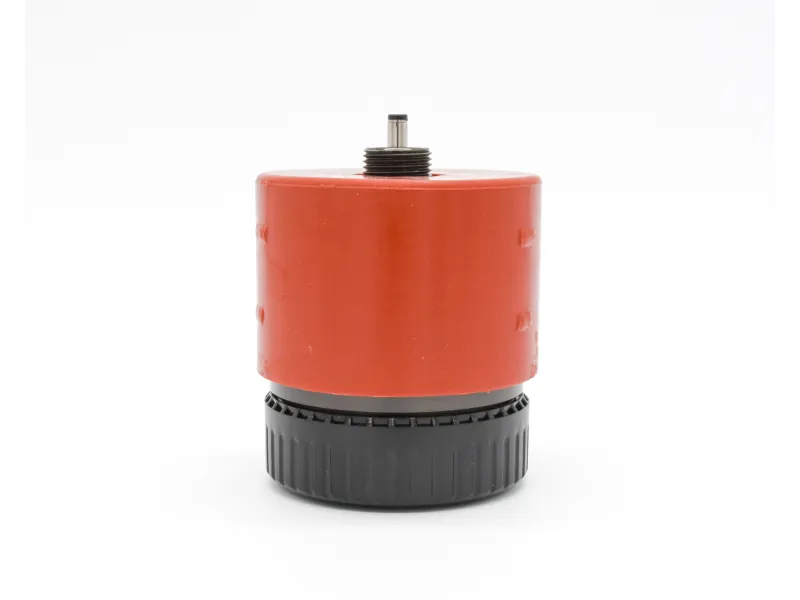 Compact red and black mechanical component with threaded metal rod on top against white background
