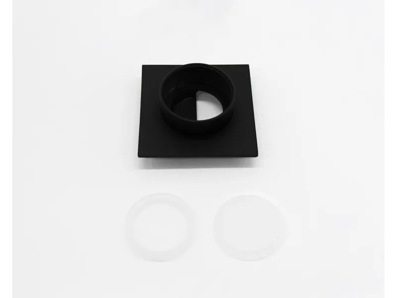 Black square lens adapter with internal threading above two translucent circular gaskets on white background