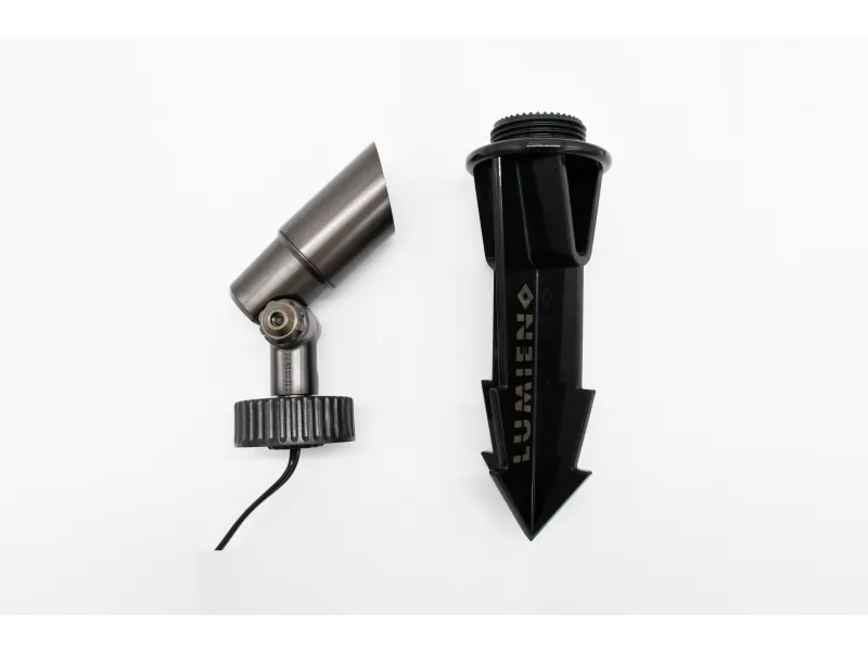 Metal garden spotlight and black plastic ground stake for outdoor lighting installation on white background