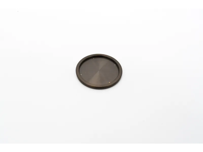 Small black circular object with a smooth surface on a white background