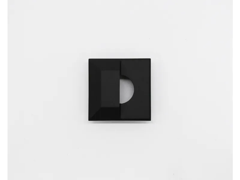 Black geometric square object with half-circle cutout detail on white background.