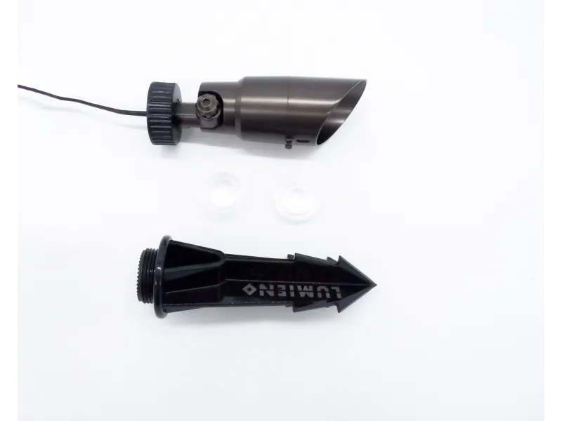 Disassembled black garden stake spotlight with spike and mounting washers on white background