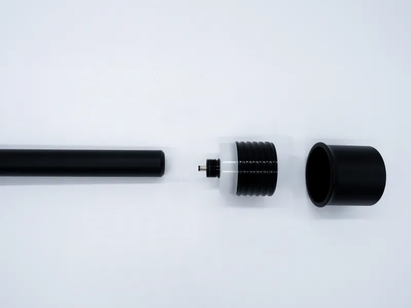 Black modular cylindrical components including a long tube, threaded connector, and cap on a white background