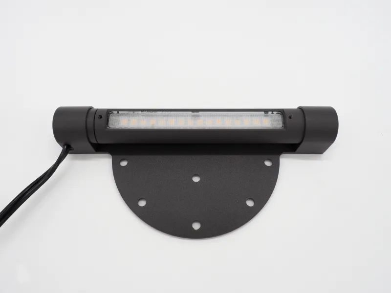 Black LED strip light fixture with mounting plate and wiring against white background