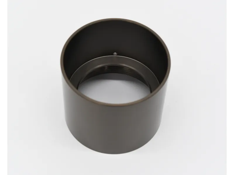 Metal cylindrical camera lens adapter tube with internal threading on white background