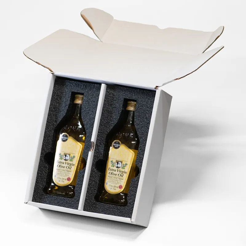 Two bottles of extra virgin olive oil securely packaged in a white box with foam inserts for protection.