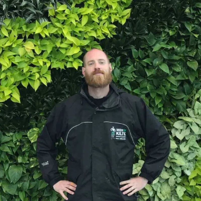 a man standing in front of a bush