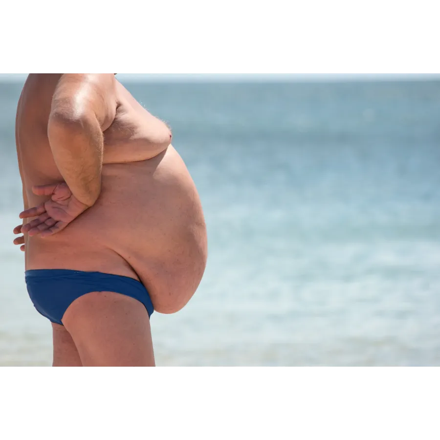 a person in a swimsuit standing in front of a body of water