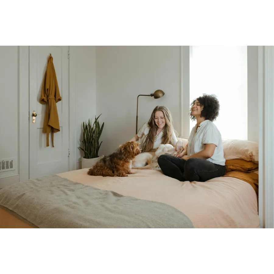 a person and a dog sitting on a bed