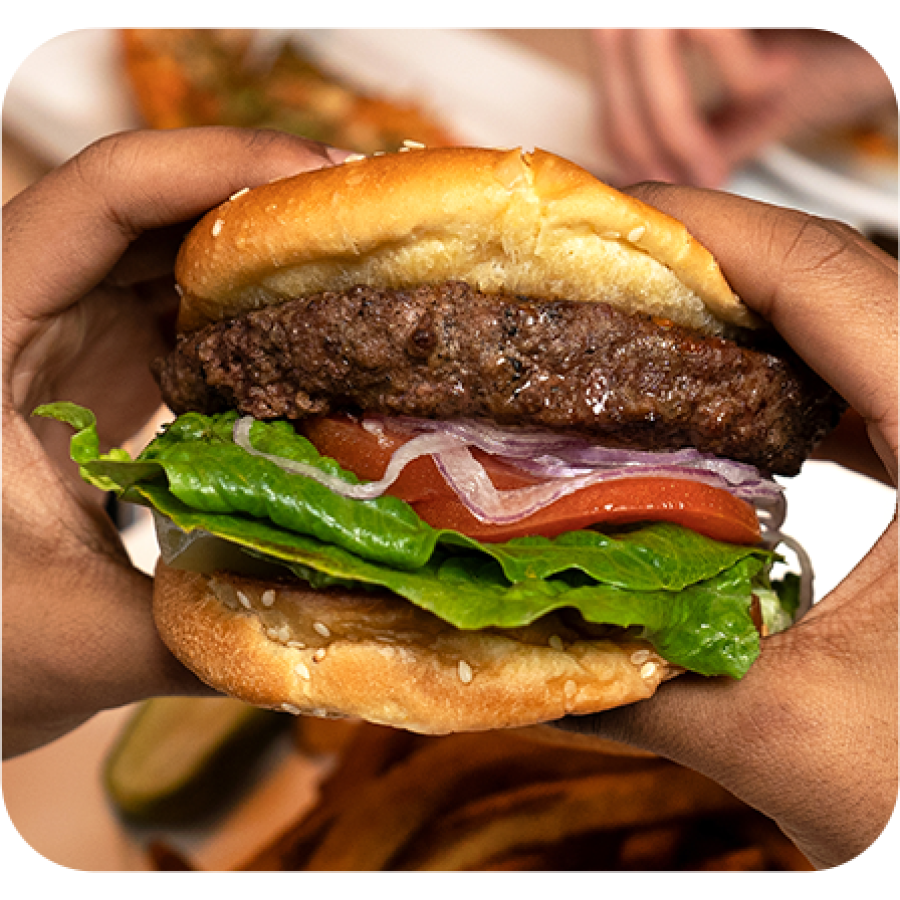 a person holding a burger