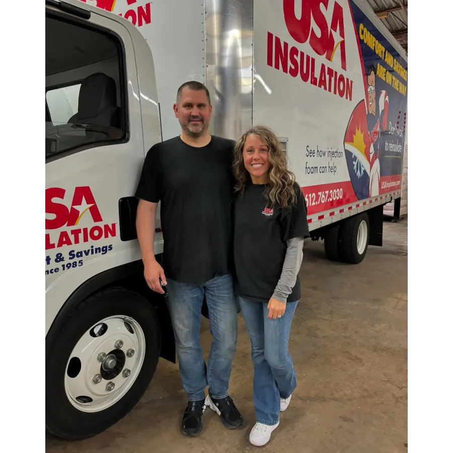Two employees of USA Insulation stand in front of a service truck, promoting insulation services.
