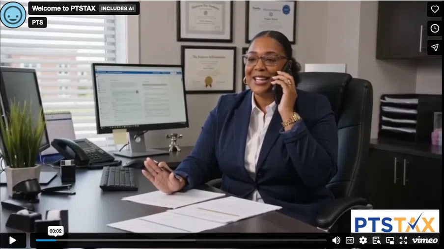 Professional woman in business attire talking on phone at desk with computer, papers, and certificates on wall