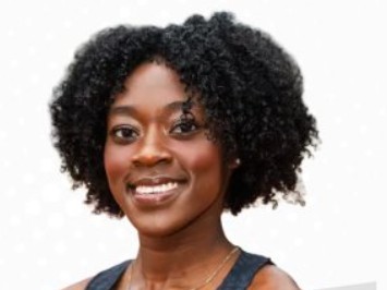 Portrait of a smiling woman with natural curly hair and warm skin tone against a plain white background