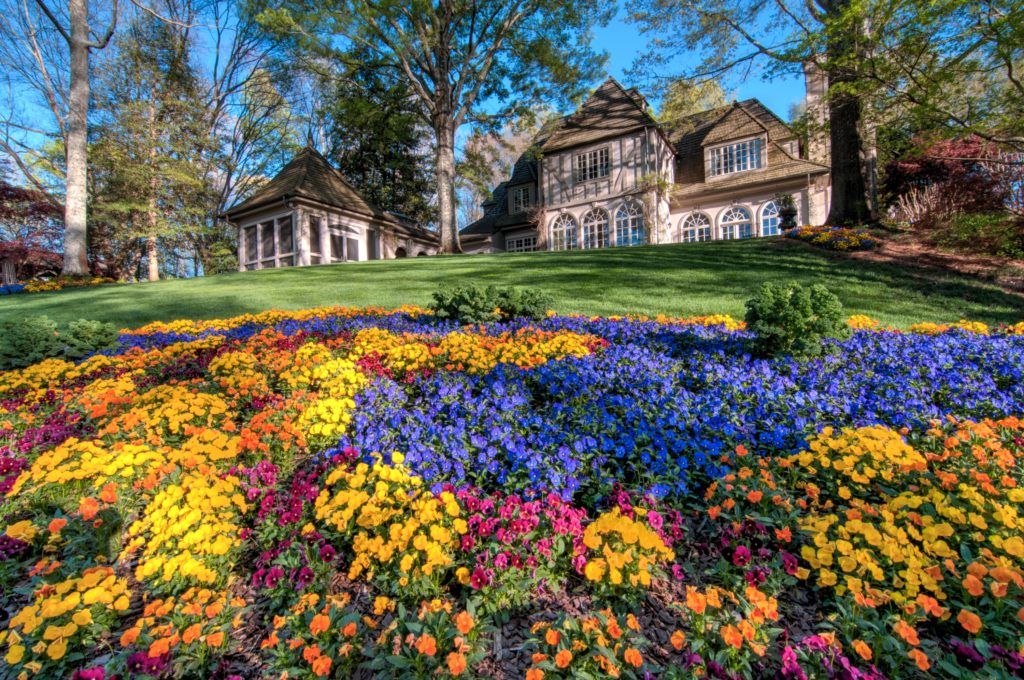 a colorful flower garden in front of a house