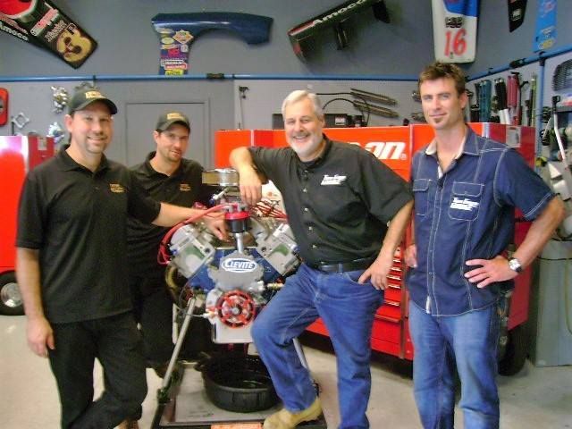 a group of men standing around a motor