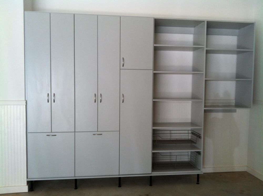 A garage storage system featuring a row of various sized cabinets and shelves 