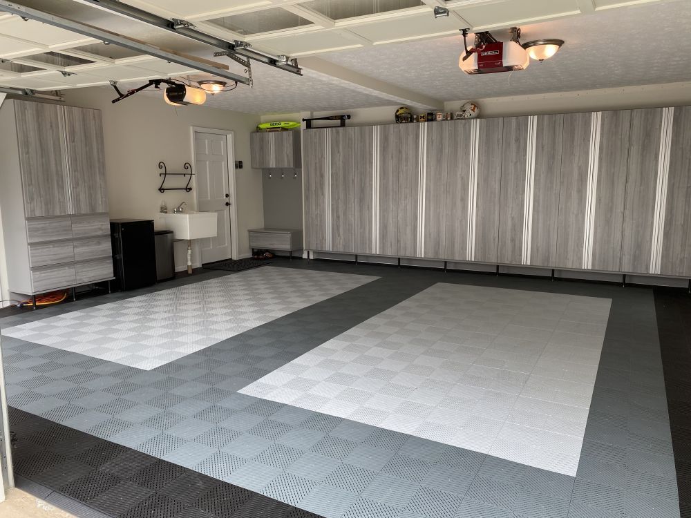 A garage storage system with light grey cabinets and specialty flooring