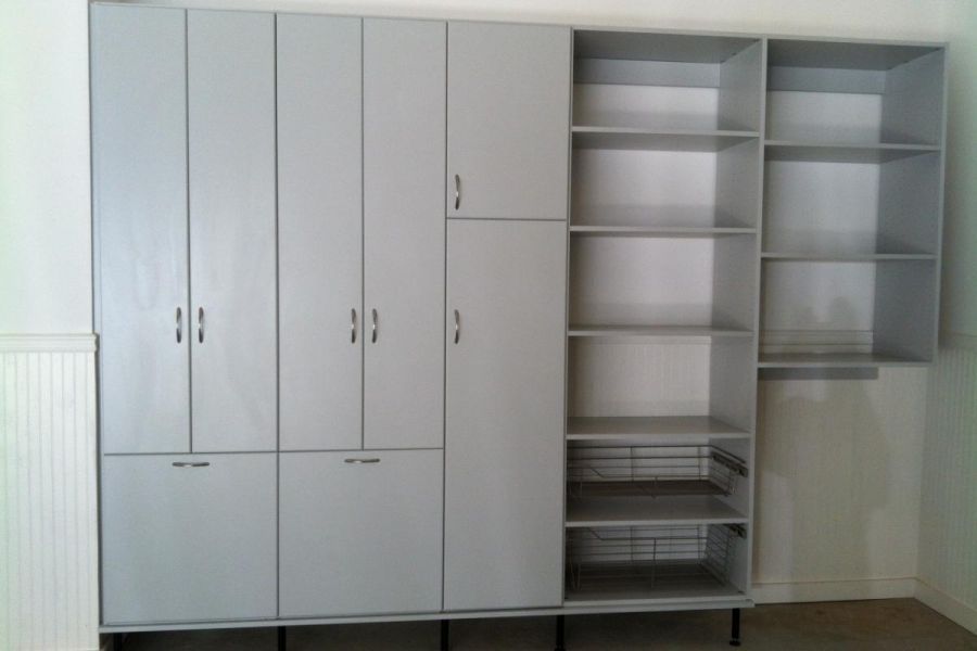 Gray cabinetry and shelving in a remodeled garage.