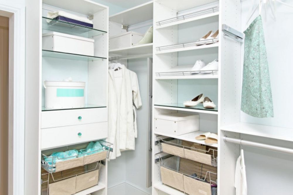 A stylish walk-in closet system with white cabinets and teal blue accents 