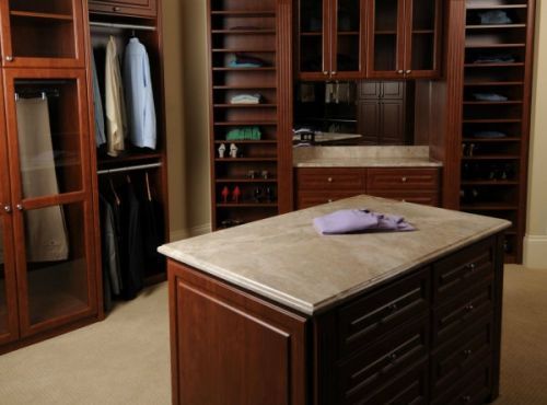 A beautiful walk-in closet system has wall-to-wall storage and a center island.