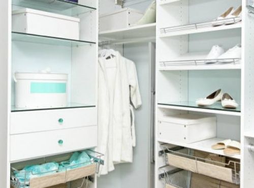 A white master closet system with glass accents.