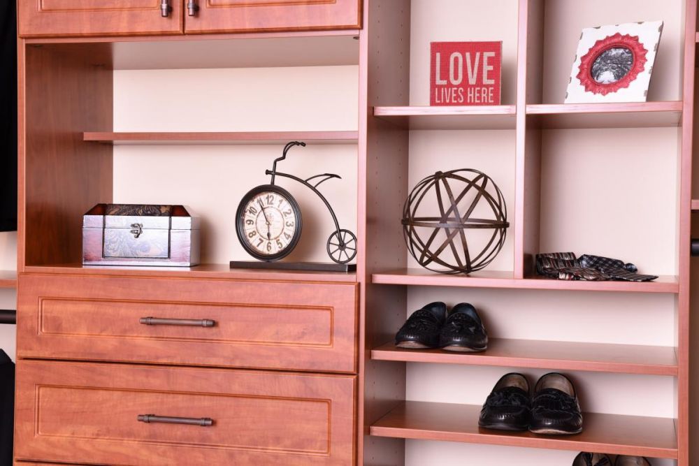 Part of a walk-in closet system with a light pink theme, featuring shelves, cabinets, and drawers