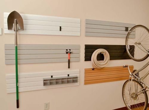 A garage storae system featuring hanging boards holding various tools and a bicycle