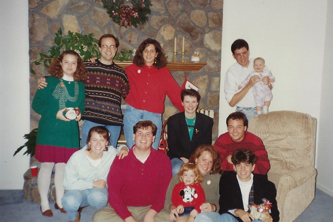 People pose in front of fireplace at Christmas