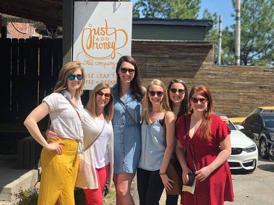 Group of women outside &quot;Just Add Honey Tea Company&quot;