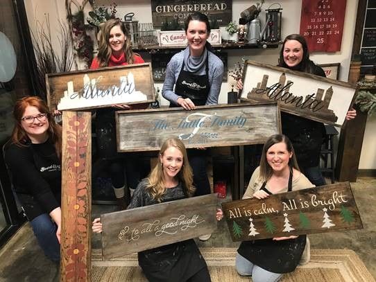 Group of Berry alums hold up painted signs at local craft store