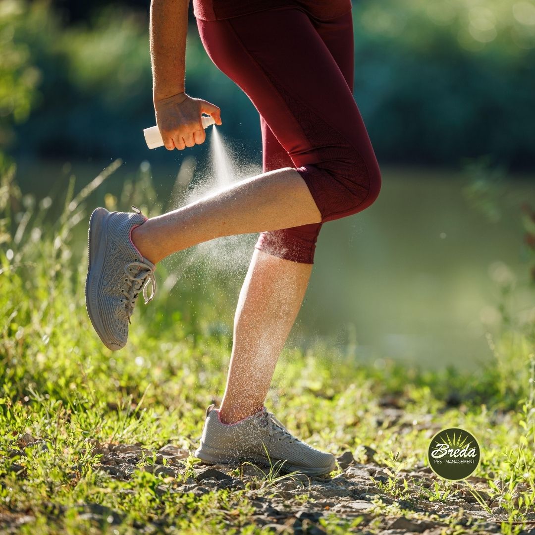 a woman spraying tick repellant on her leg before going on a hike in Georgia tick pest control in Atlanta