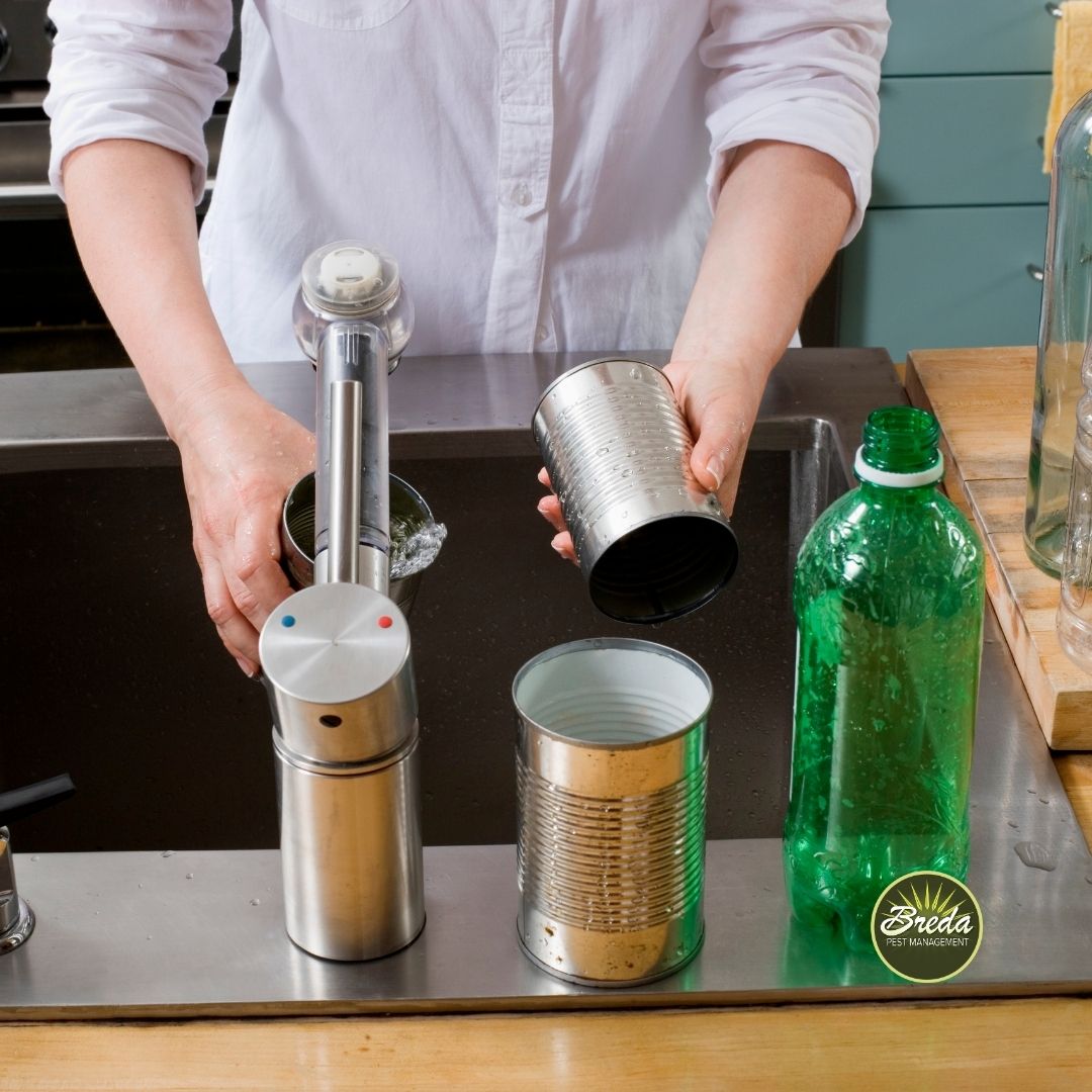 man rinsing his recycling items at the kitchen sink before throwing them away fruit fly pest control in Georgia