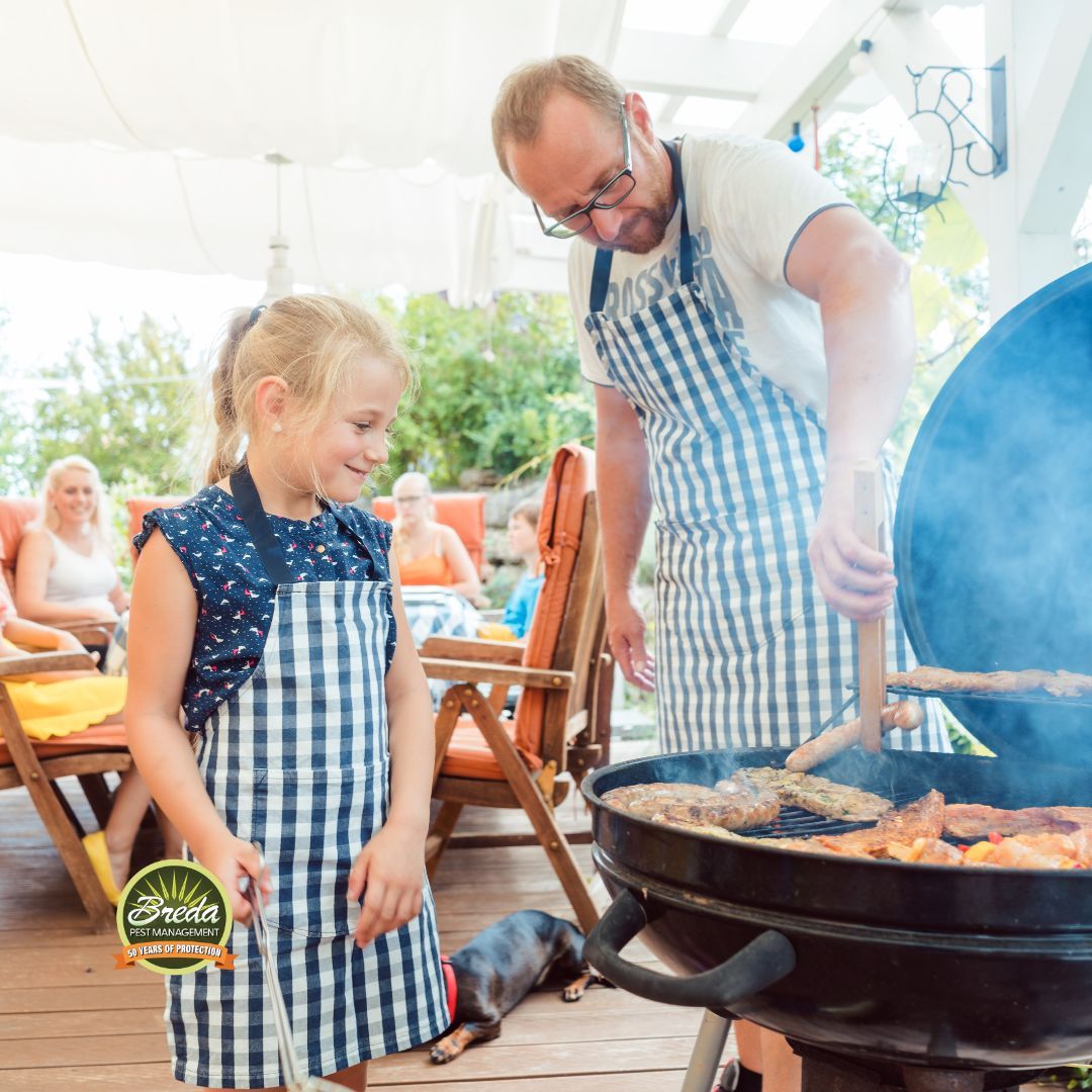 father and daughter cooking food on a grill at backyard BBQ mosquito control metro Atlanta