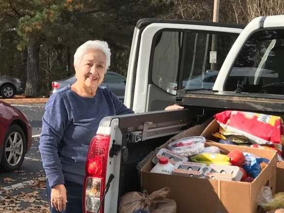 Woman by truck with food for delivery