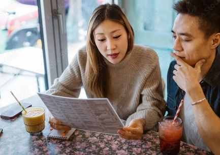 A woman and a man looking over a restaurant menu