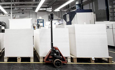 Pallets of large paper sheets in a printing company's storeroom